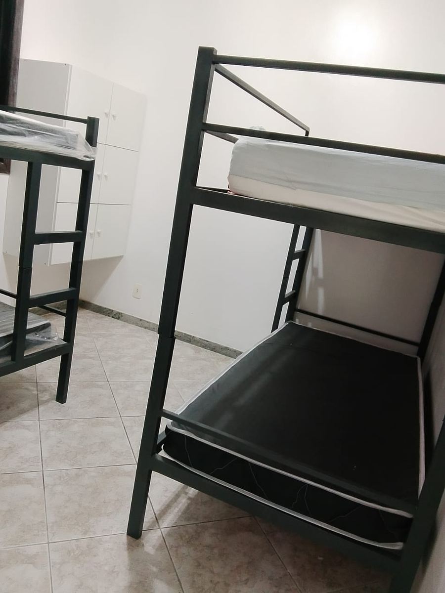 Quarto claro com camas organizadas e armário na clínica de reabilitação em Itaúna
