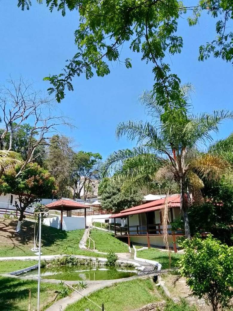 Vista geral da clínica de reabilitação em Itaúna com lago, palmeiras e chalés